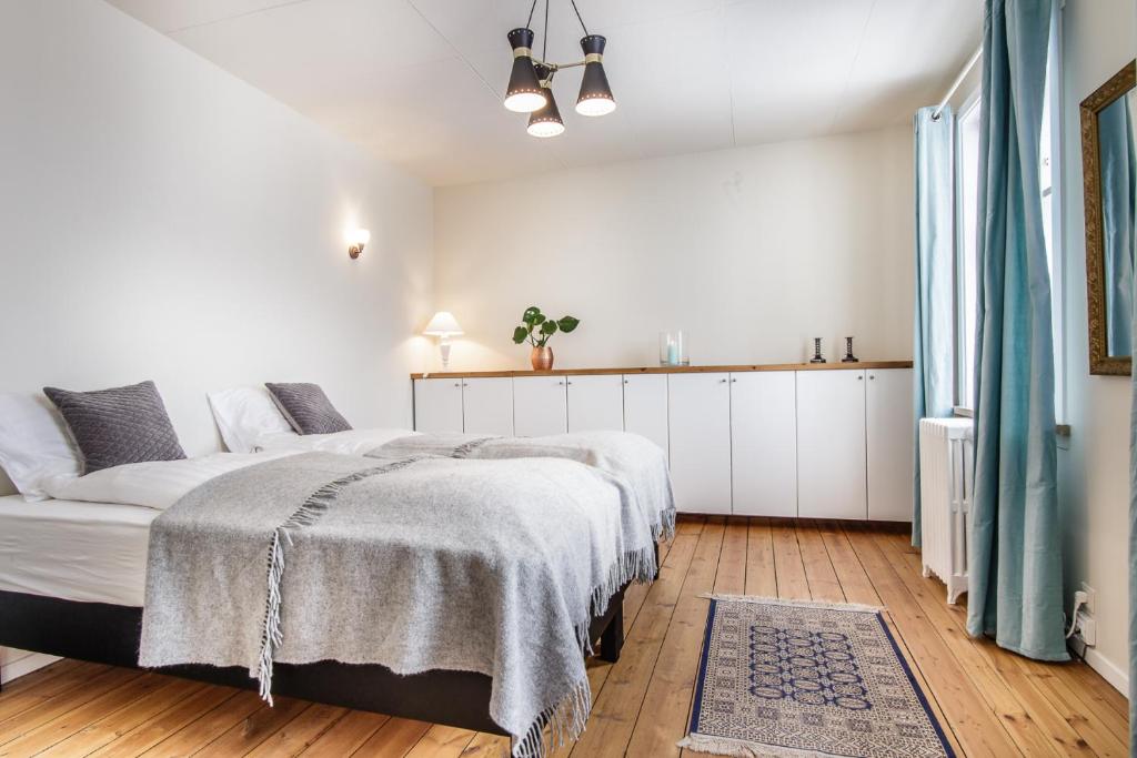 a white bedroom with a large bed in it at Englendingavík Homestay in Borgarnes