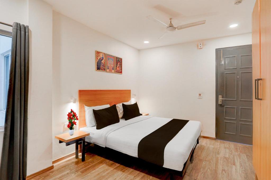 a hotel room with a bed and a door at OYO Townhouse Deva Road Lucknow in Lucknow