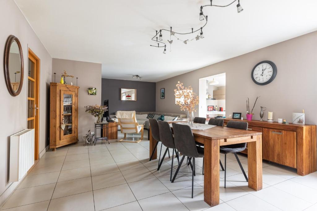 a dining room and living room with a table and chairs at Maison Ferrer - avec jardin clos in Villeneuve-le-Roi