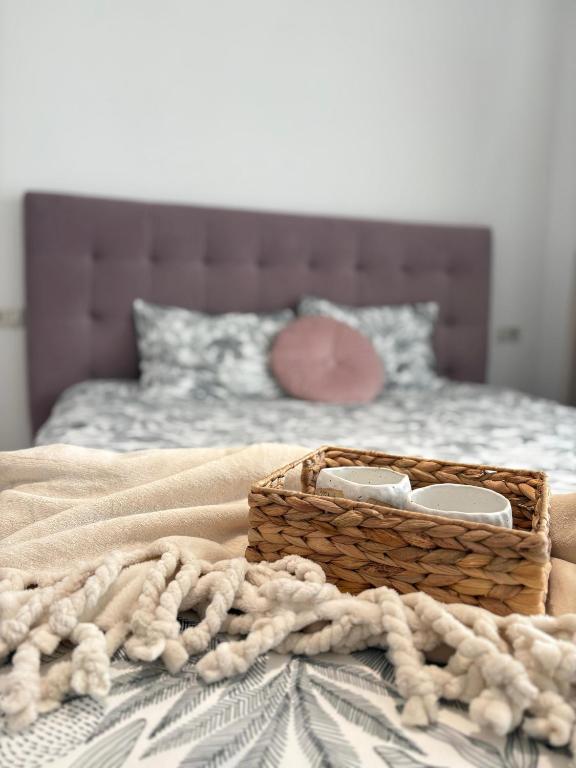 a basket sitting on top of a bed with a blanket at Warm apartament 3 in Bucharest