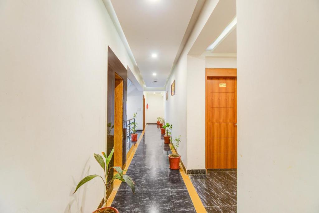 a corridor of a building with potted plants at Palette by CheckIn Goverdhan Villas Formerly The White Fresco in Udaipur