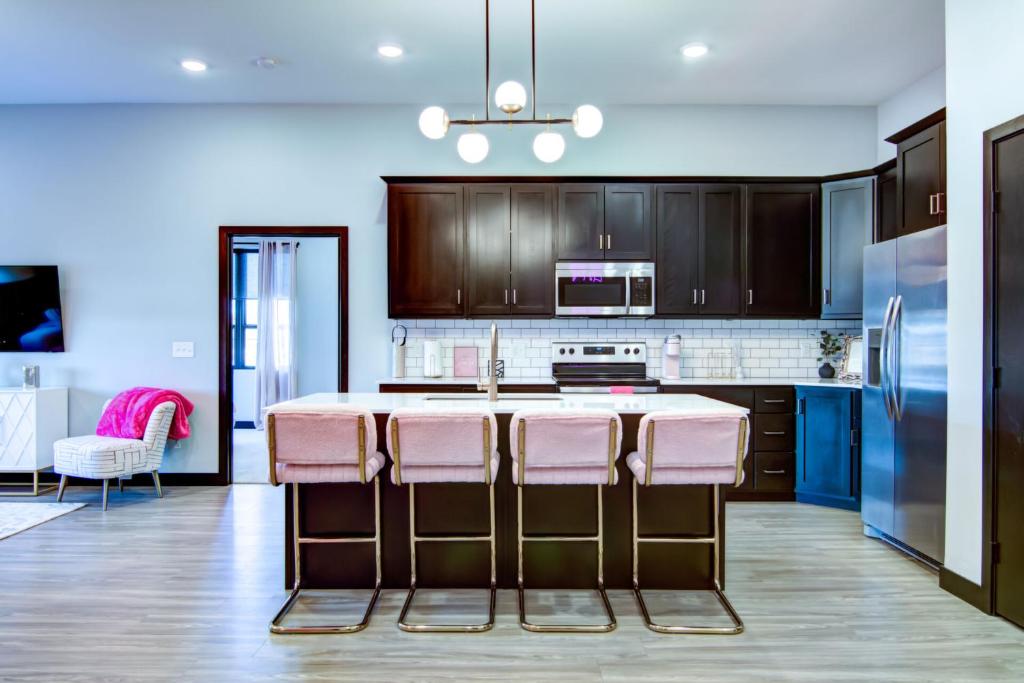 a kitchen with a kitchen island with pink bar stools at Fairway in Altoona