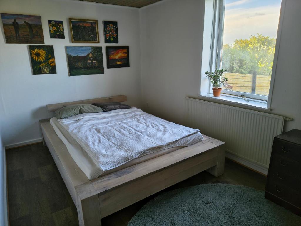 a bedroom with a bed in a room with a window at Cozy guest house with terrace in Aalborg