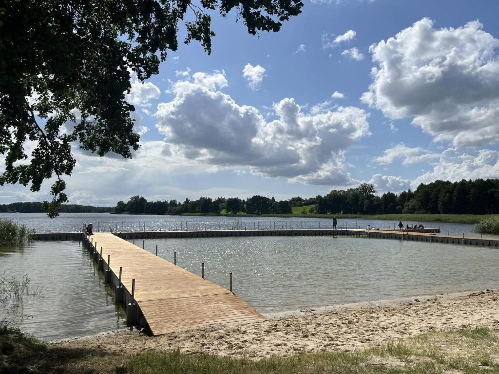 a dock in the middle of a large lake at Wzgórze za miedzą - Niezależne Studio z osobnym wejściem in Sicienko