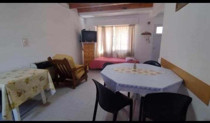 a room with a table and chairs and a bedroom at Complejo el Cuy in Las Grutas