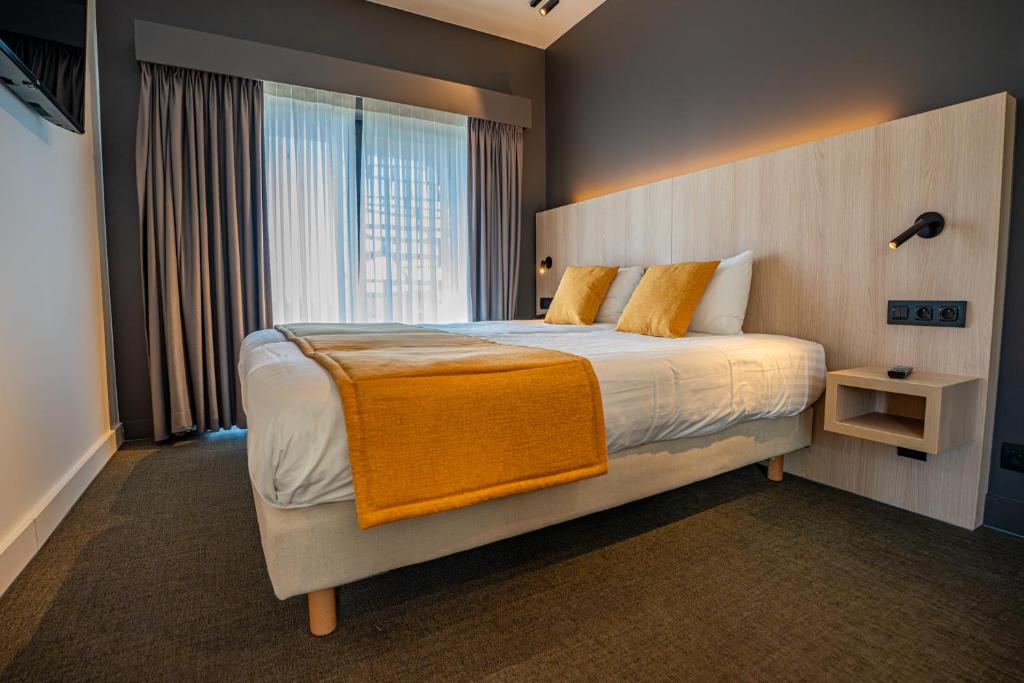 a bedroom with a large bed and a large window at Hôtel & Restaurant Five Nations in Durbuy