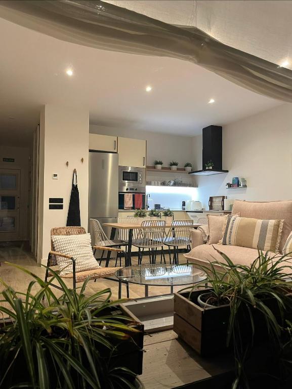 a living room with couches and a table and a kitchen at Los Cucos in Cabezuela del Valle