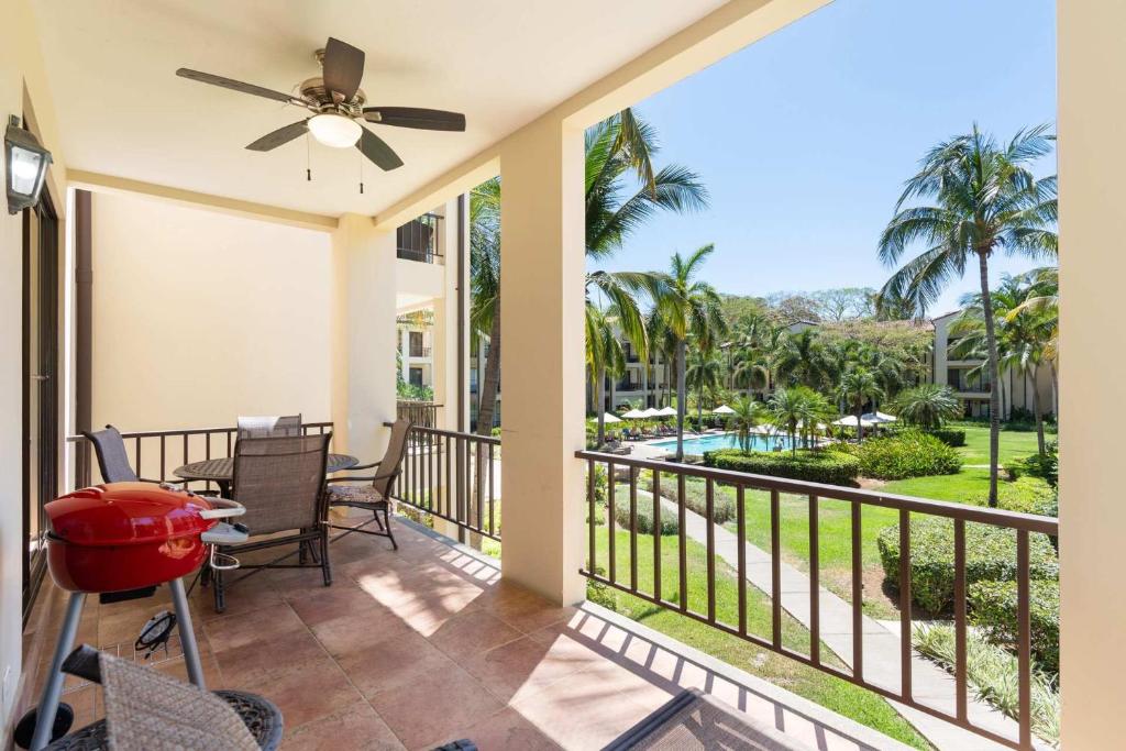 a balcony with a table and chairs and a ceiling fan at Vibrant 3-Bedroom Condo with Resort Amenities, Pools & Beach Club Access in Coco