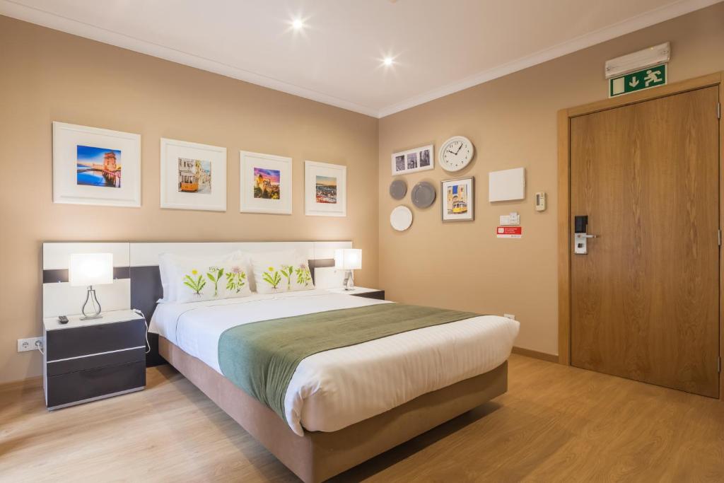 sypialnia z dużym łóżkiem i drewnianymi drzwiami w obiekcie Vila Nova Guesthouse w Lizbonie