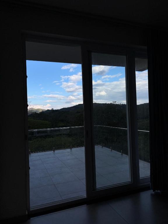 two windows in a room with a view of a tennis court at Horizon house in Vagamon