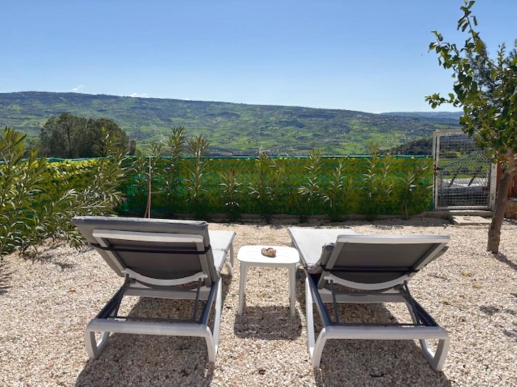 two chairs and a table on a patio with a view at St Visianos stone house in Philousa