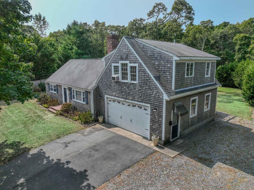 a small house with a garage and a driveway at Beautiful Property w Separate Apartment in Brewster