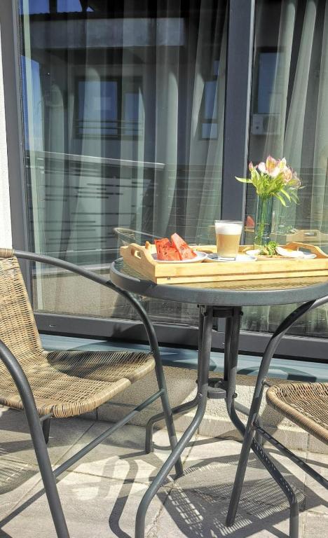 a table with a plate of food and flowers on it at YMY Boutique Residence in Bucharest