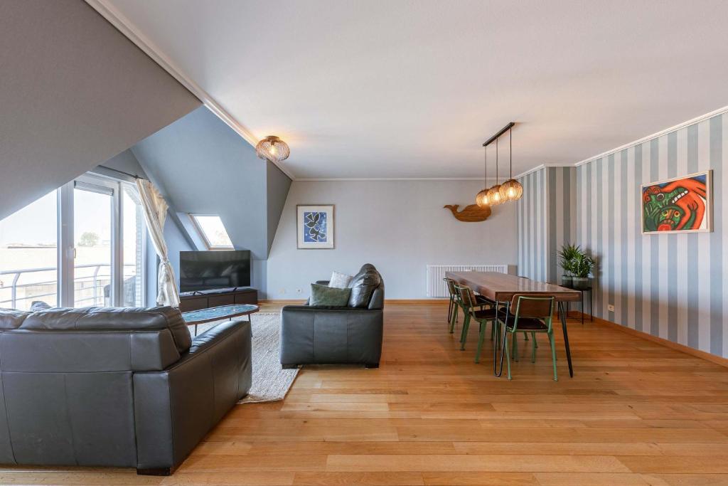 a living room with a table and a dining room at Casiola - Comfortable Apartment with Scenic Views in De Haan