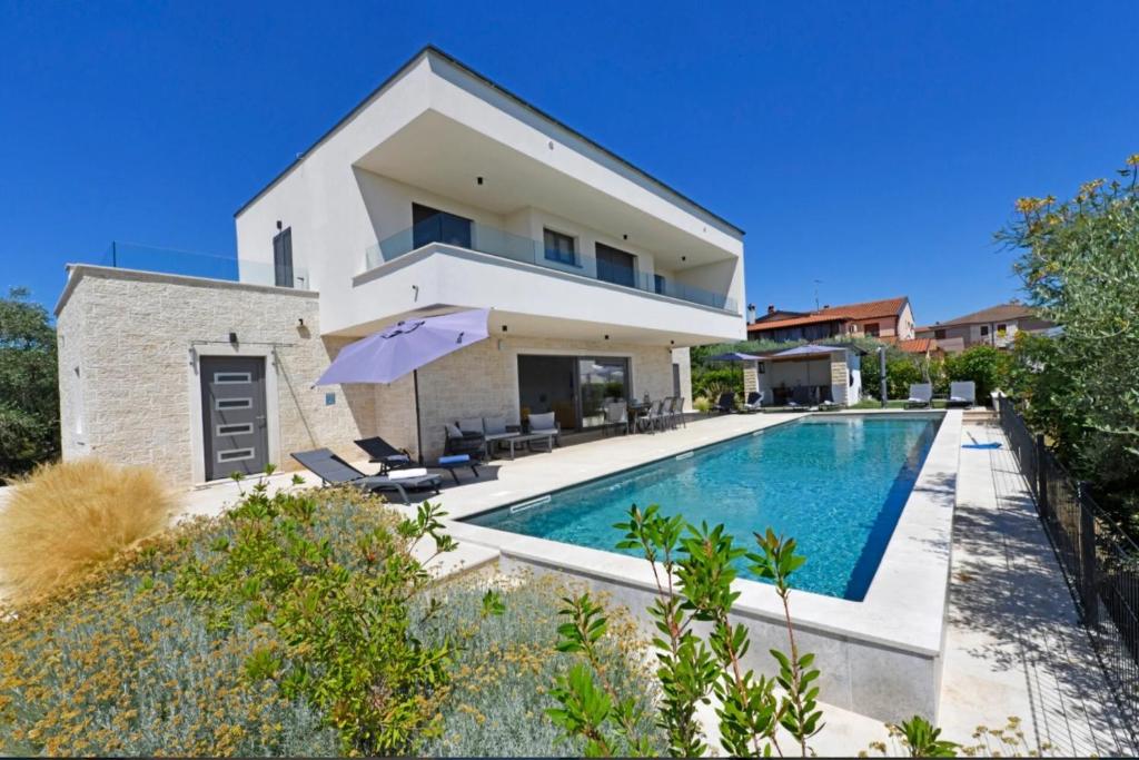 a house with a swimming pool in front of a house at Villa Mila in Vabriga