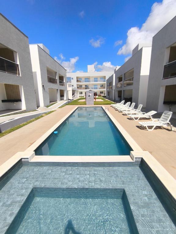a swimming pool in front of a building at Apartamento Jacumã -Conde-PB in Conde