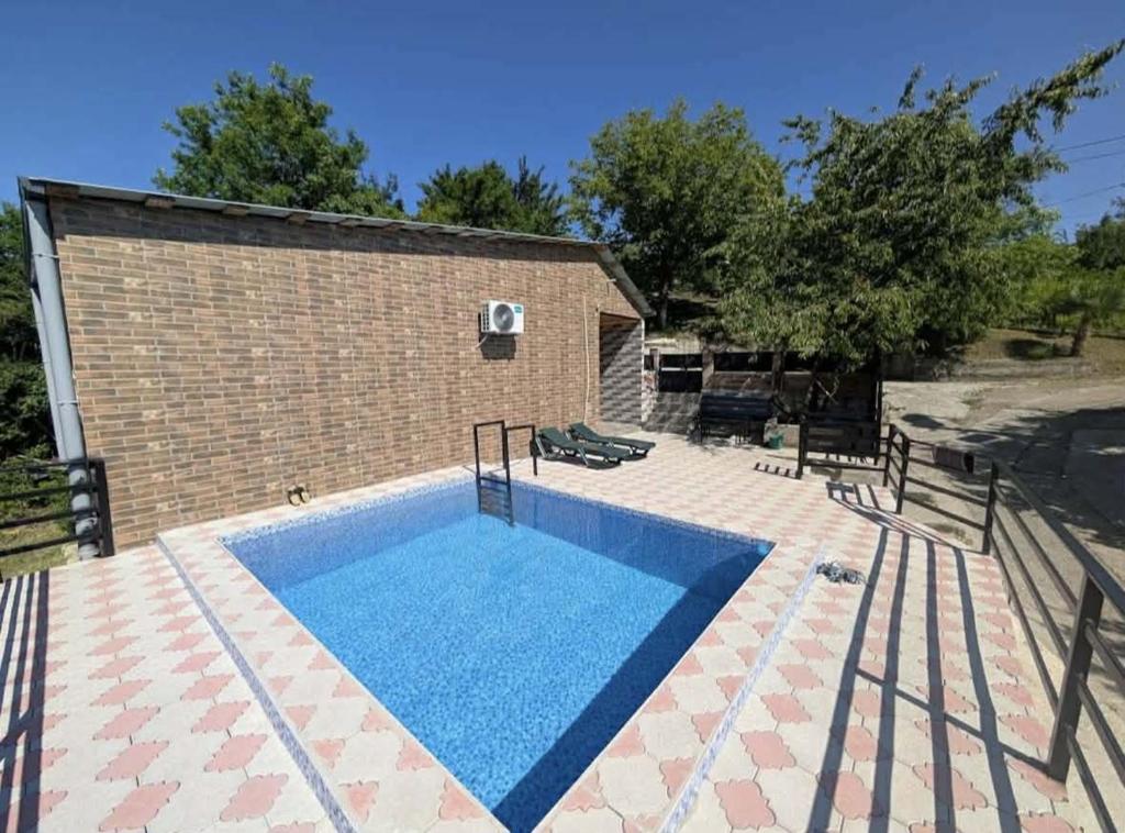 a swimming pool in front of a brick building at Apartment BESO in Kutaisi