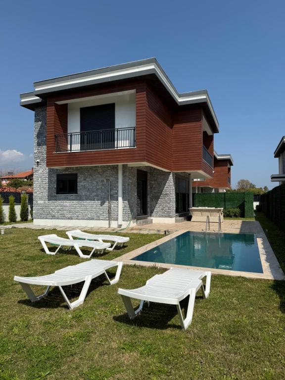 a villa with a swimming pool in front of a house at Tekirova DOM Villas with Heated Pool in Kemer