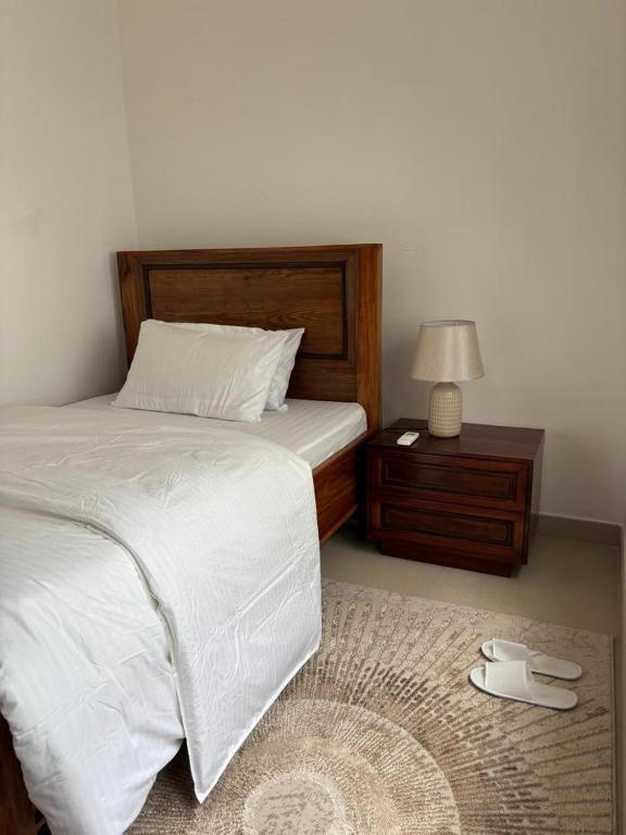a bedroom with a bed and a table with a lamp at Coastal Escape Haven in Mchamba Wima