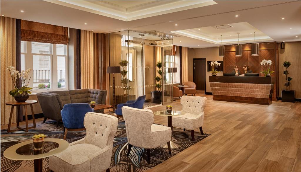 a hotel lobby with chairs and a table at The Westbourne Hyde Park in London