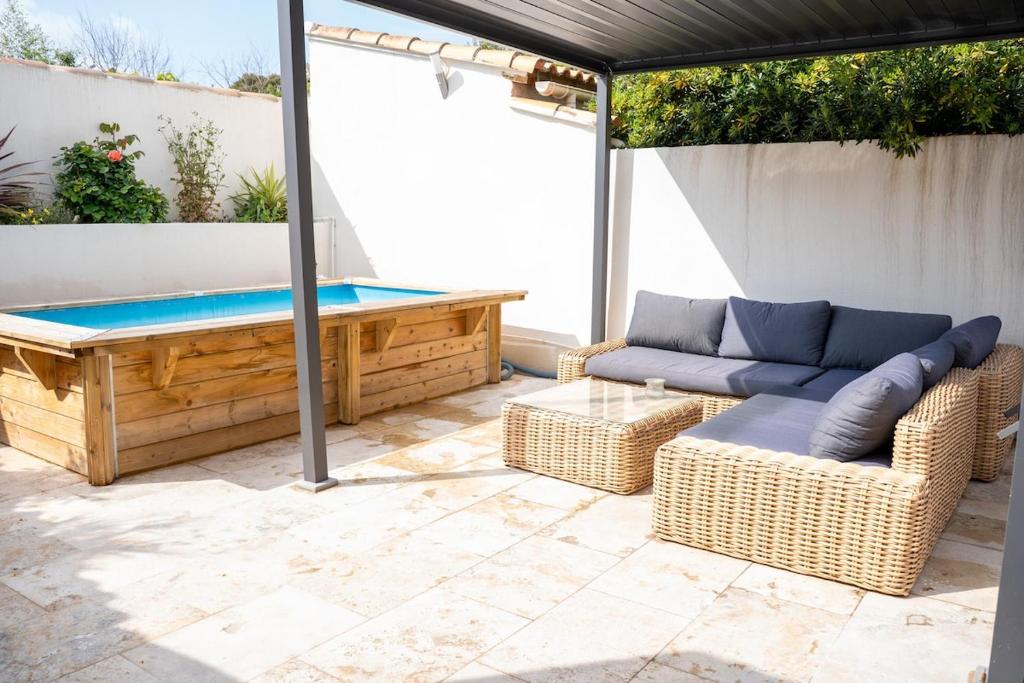 a patio with a pool table and wicker furniture at Villa Champan in La Ciotat