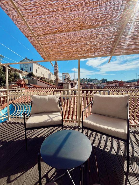 two chairs and a table on a balcony with a view at Franka Apartment in Piran