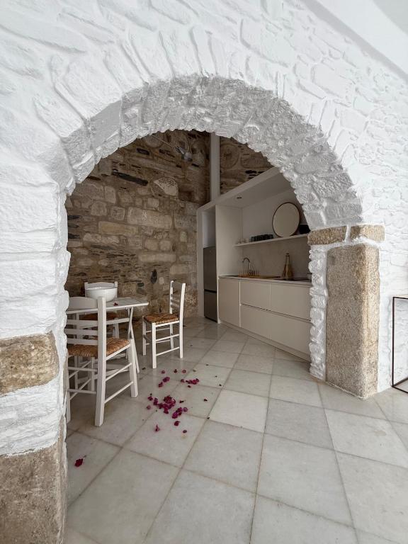 a kitchen and dining room with a stone wall at Ancient Wall House in Kampos Paros