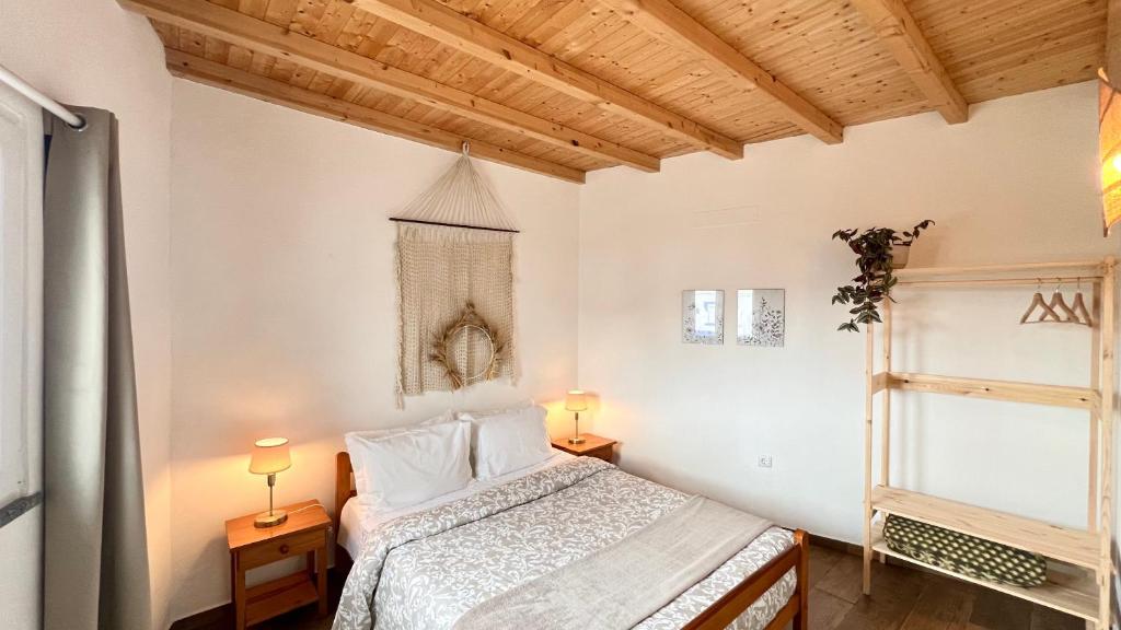 a bedroom with a bed and two lamps and a window at Casa do Mestre in Amieira