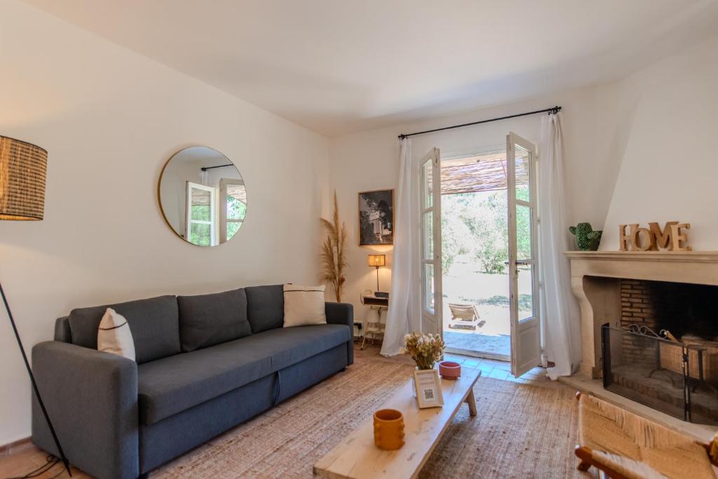 a living room with a couch and a fireplace at Maison avec jardin proche plages & village in Gassin