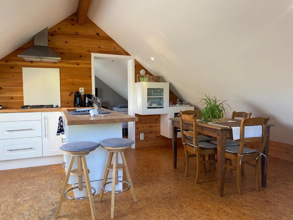 a kitchen with a table and stools in a room at Studio à la campagne in Jalhay