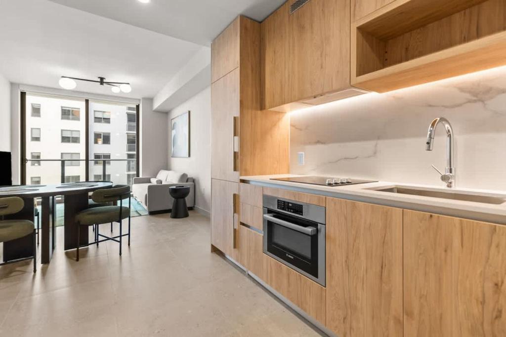 a kitchen with wooden cabinets and a sink and a table at Downtown Luxury Condo withPool & Skyline Views in Miami