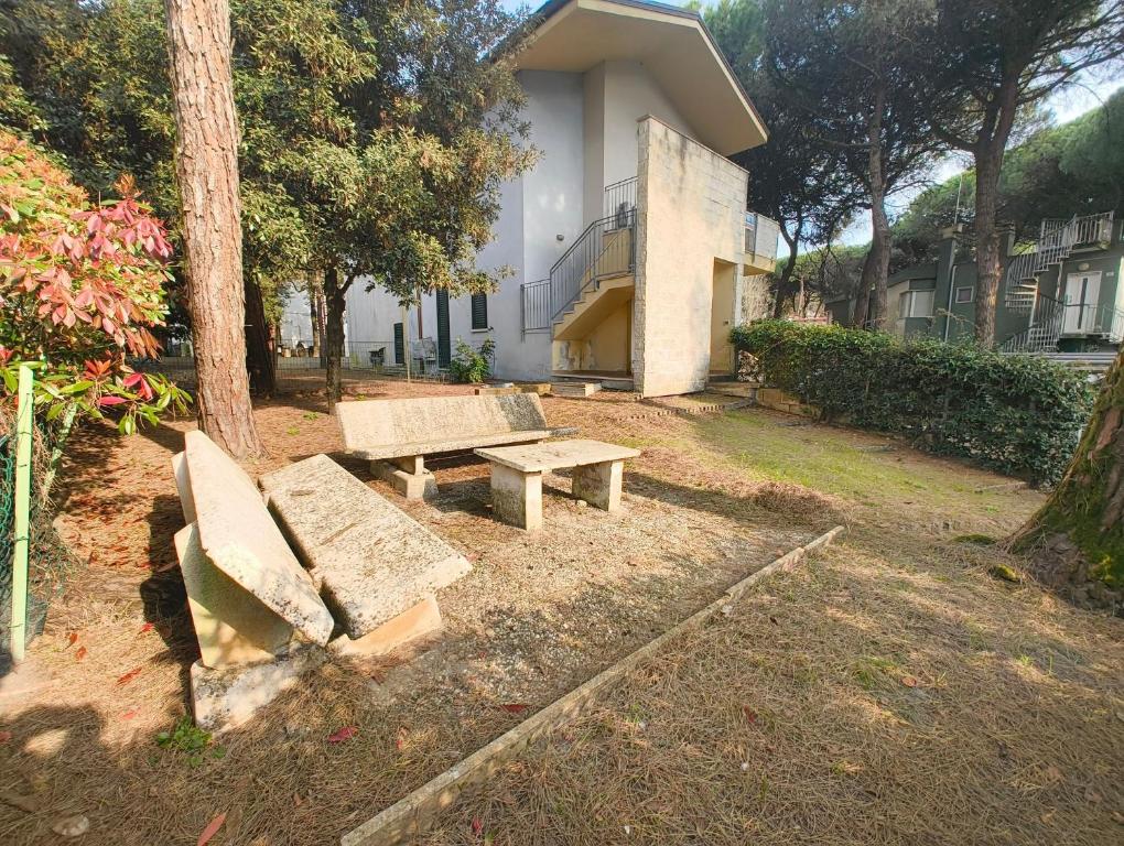 a couple of benches sitting in front of a building at Cozy flat near the centre of Rosolina Mare in Rosolina Mare