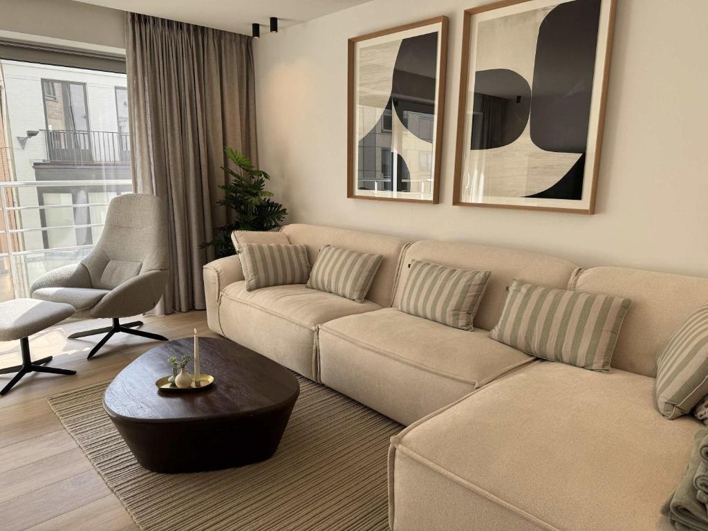 a living room with a couch and a table at Casiola - Design apartment with sea views in Knokke-Heist