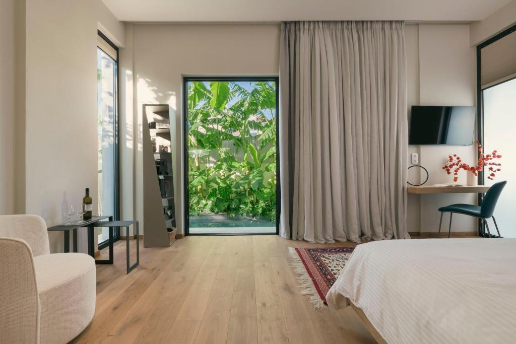 a hotel room with a bed and a large window at Nõs Luxury Rooms in Missolonghi