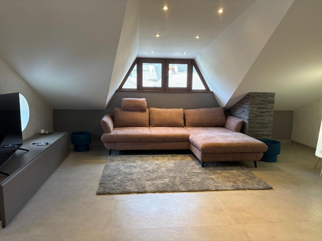 a living room with a couch in the attic at Apartment Jasmina in Venzone