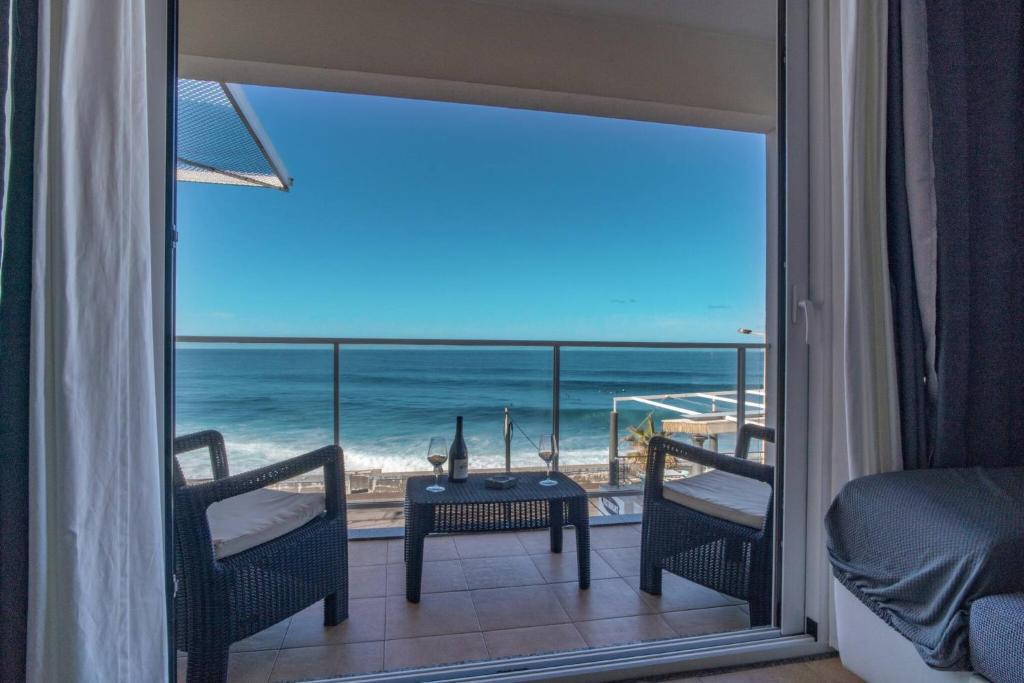 a room with a balcony with a view of the ocean at Apartment 7 on Paul do Mar Beach in Paul do Mar