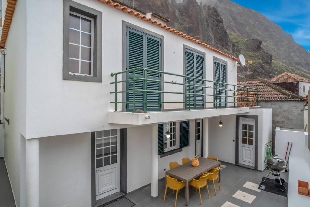 a house with a balcony with a table and chairs at Villa Alegra Paul do Mar in Paul do Mar