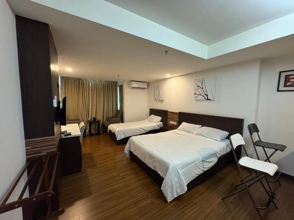 a hotel room with two beds and a television at EasyStay Studio Apartment KBCP in Kota Bharu