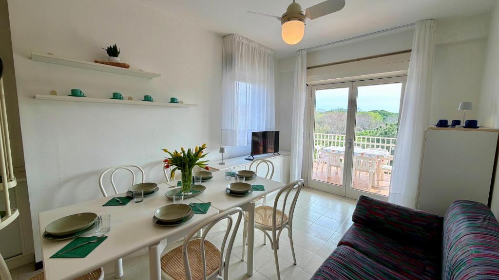 a living room with a table and chairs and a window at apartament skyline park residense in Lignano Sabbiadoro