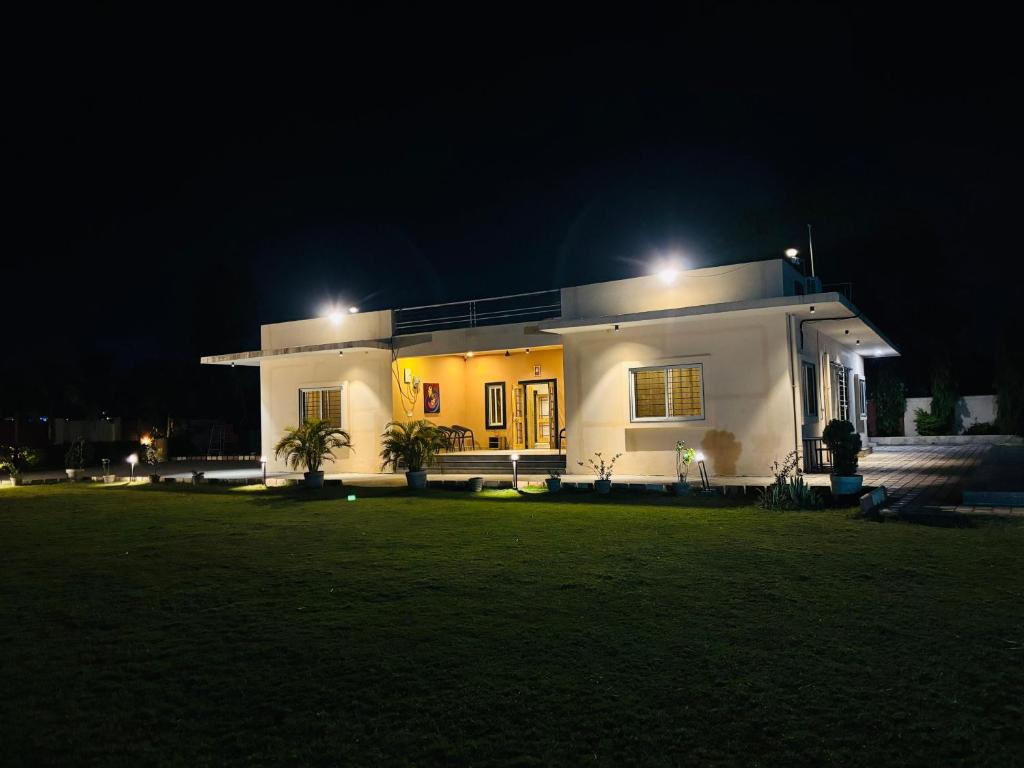 a large white house with lights on it at night at Courtyard Villa in Bhopal