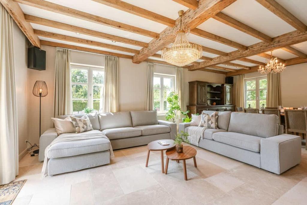 a living room with two couches and a table at Casiola - Authentic Serene Vacation Hideaway with Pond in Harelbeke