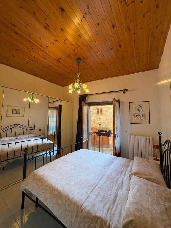 a bedroom with two beds and a wooden ceiling at casa cosetta in Gambassi Terme