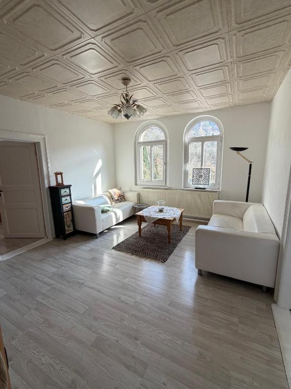 a living room with two white couches and a table at Im Herzen des Elbsandsteingebirges in Königstein an der Elbe
