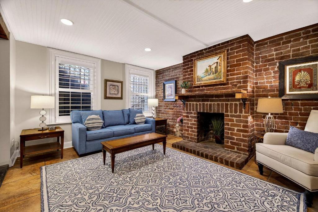 a living room with a couch and a brick fireplace at Troup Square Manor Garden by Lucky Savannah in Savannah