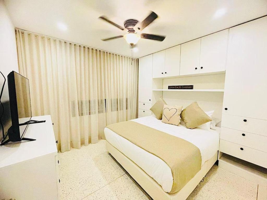 a bedroom with a bed and a ceiling fan at Apartahotel MONACO in Ginebra