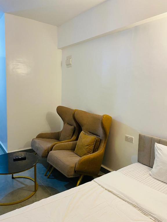 a bedroom with a couch and a table and a bed at Elevate Homes in Nairobi