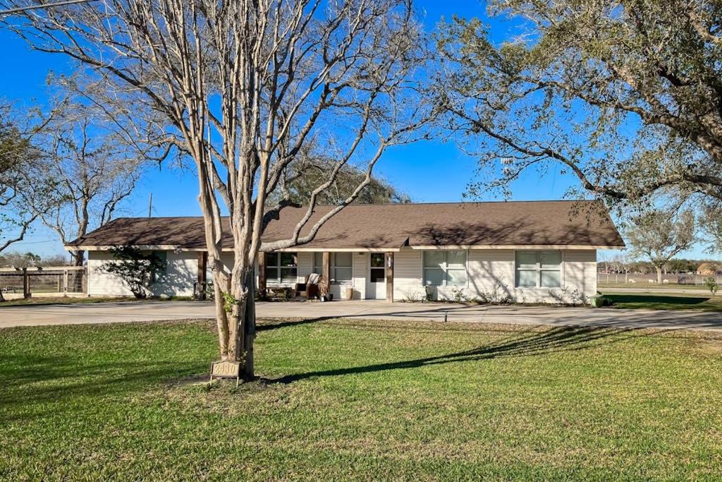 a white house with a tree in front of it at R&R Acres in Aransas Pass