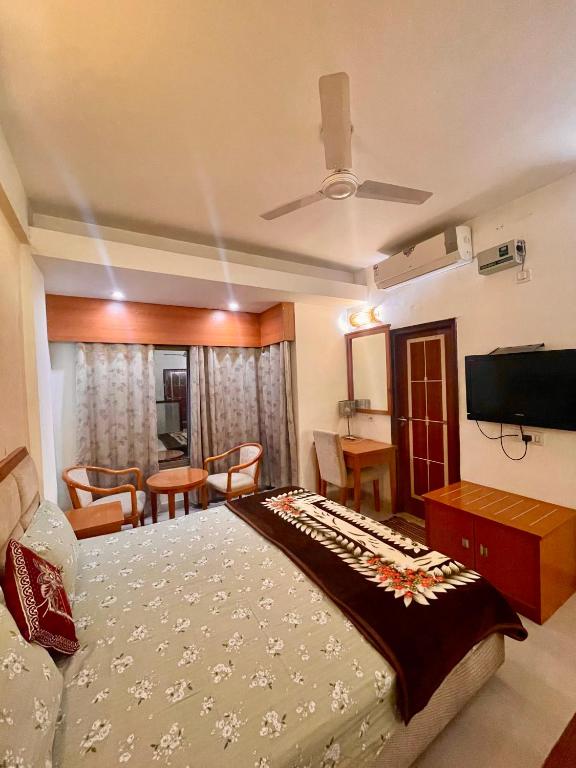a bedroom with a large bed and a television at ZenRoofs- 02 Studio Apartment in Vrindāvan