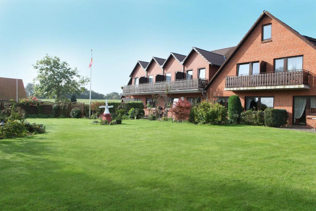 a large house with a large lawn in front of it at Pension Tüxen in Hasselberg