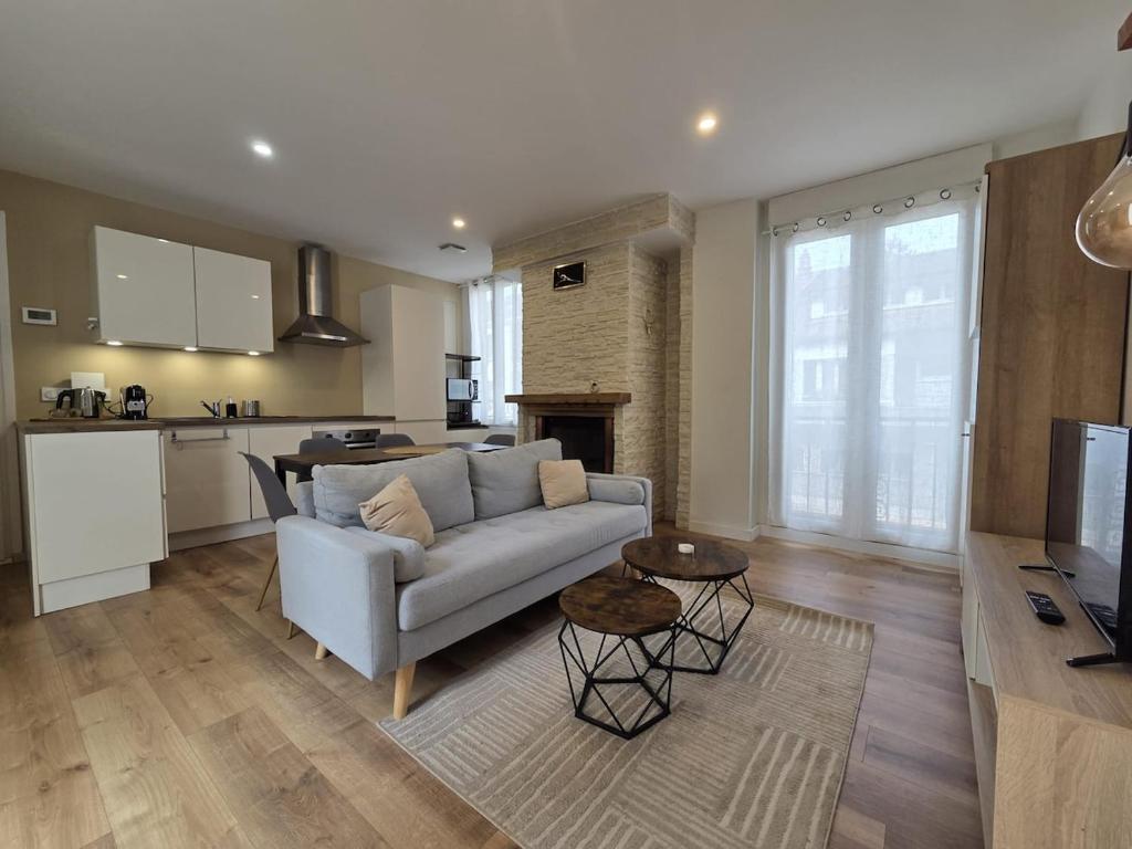 a living room with a couch and a kitchen at La Charmante in Évian-les-Bains